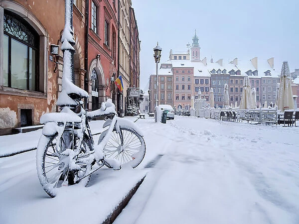 Snow covered bicycle at the Old Town Main Market Square, winter, Warsaw, Masovian Voivodeship, Poland
