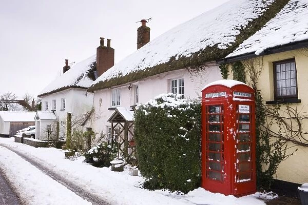 Snow covered cottages and traditional phone box in the village of Morchard Bishop