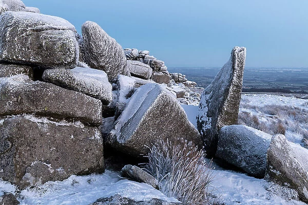 Snow covered granite outcrop at Belstone Tor in Dartmoor National Park, Devon, England. Winter (December) 2022