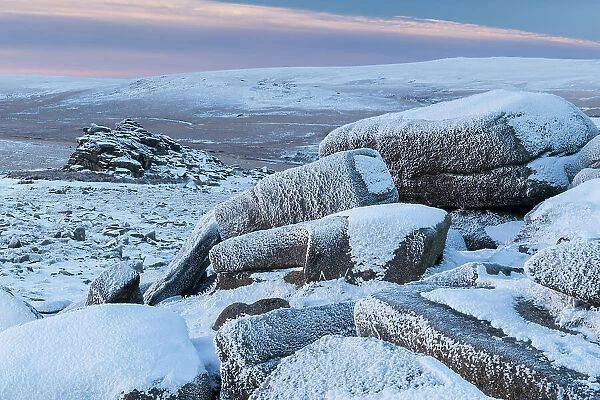 Snow covered granite outcrops at Belstone Tor in Dartmoor National Park, Devon, England. Winter (December) 2022
