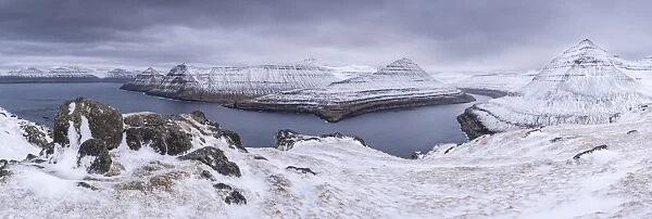 Snow covered mountain scenery above Funningsfjordur on the island of Eysturoy, Faroe Islands