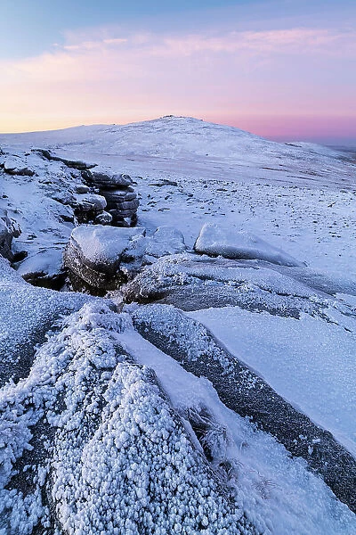 Snow and ice covered moorland at dawn on West Mill Tor in Dartmoor National Park, Devon, England. Winter (December) 2022