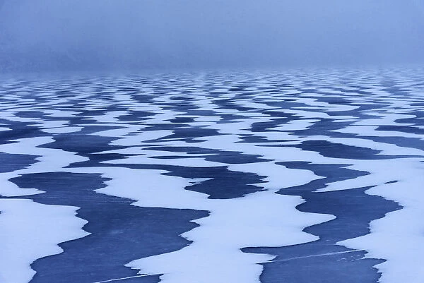 Snow textures shaped by the wind on a frozen lake in the Lofoten islands, Norway