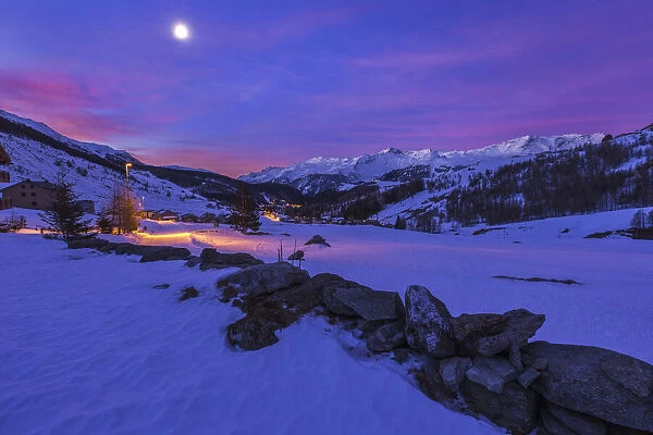 Snowy dawn on Madesimo village with moon, Sondrio province, Spluga valley, Lombardy