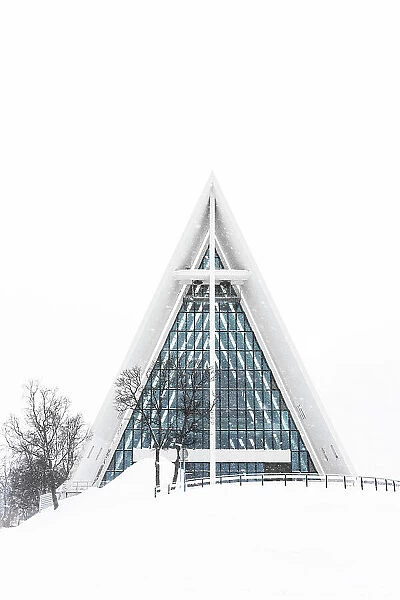 Snowy facade of the Arctic Cathedral decorated with glass windows, Tromso, Norway
