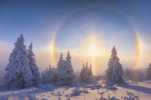 Solar halo in deep snow-covered winter landscape at Fichtelberg at sunset