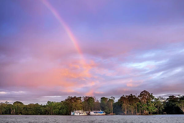 South America, Brazil, Amazon, Amazonas state, Rio Negro, traditional wooden Amazon river boats with a rainbow and gallery rainforest