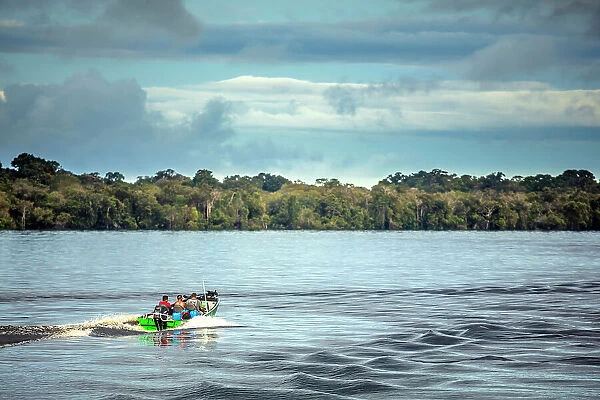 South America, Brazil, Amazonas, Amazon, Rio Negro, a fishing launch on the river near Barcelos, with gallery forest in the distance