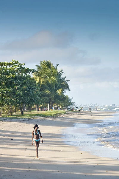 South America, Brazil, Bahia, a black Brazilian model in a bikini woman walks along