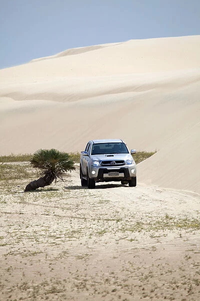 South America, Brazil, Maranhao, Toyota Hilux driving through the sand dunes in the