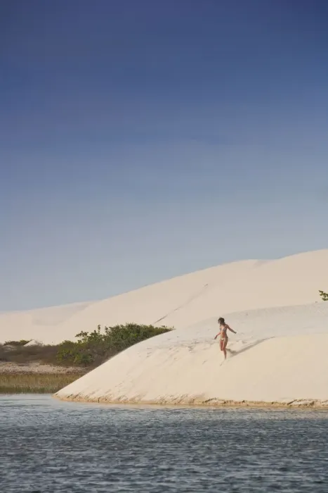 Framed Print : South America, Brazil, Maranhao, a woman in a bikini descends a dune in the Lagoa