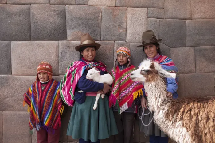 Framed Print : South America, Peru, Cusco. Quechua people standing in front of an Inca wall, holding