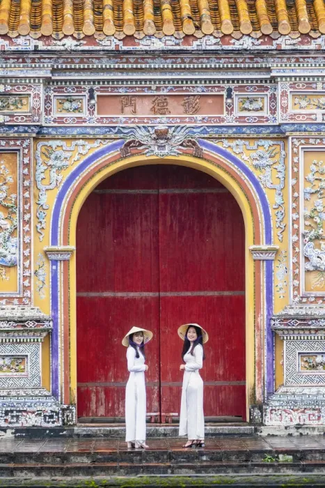Framed Print : Southeast Asia, Vietnam, Hue. Two young women wearing Ao Dai dresses stand next to an Framed Print : Southeast Asia, Vietnam, Hue. Two young women wearing Ao Dai dresses stand next to an