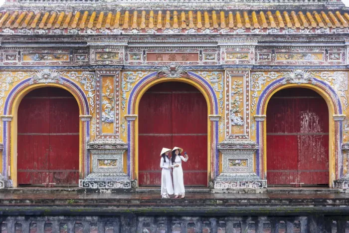Framed Print : Southeast Asia, Vietnam, Hue. Two young women wearing Ao Dai dresses stand next to an Framed Print : Southeast Asia, Vietnam, Hue. Two young women wearing Ao Dai dresses stand next to an