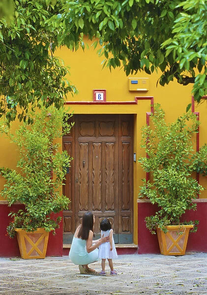 Spain, Andalucia, Seville, Woman and child infront of traditional doorway (MR)