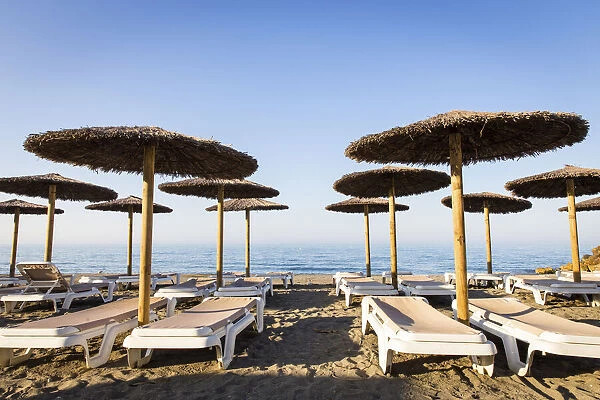 Spain, Andalusia, Malaga, El Palo, Sun beds and beach umbrellas