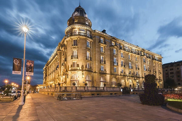 Spain, Basque Country, San Sebastian (Donostia). The luxury Maria Cristina Hotel at dusk