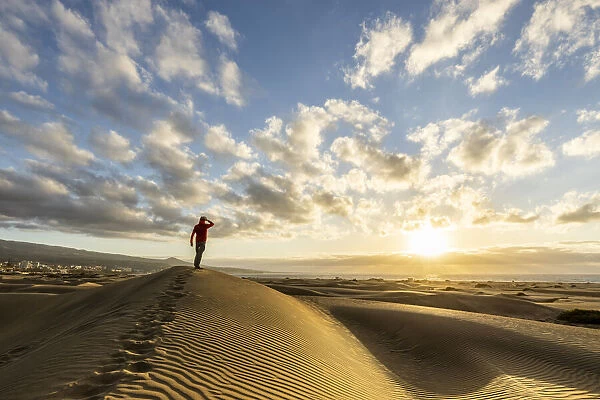 Spain, Canary Islands, Gran Canaria, a man admires the sunrise from the dunes of Maspalomas (MR)