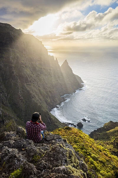 Spain, Canary Islands, Tenerife, hiker photographs cliffs of Anaga Rural Park (MR)