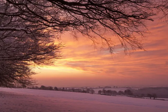 Framed Print : Spectacular dawn sky above snow covered countryside, Exmoor, Somerset, England. Winter