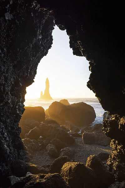 the stacks of Vik i Myrdal, seen from an hidden cave during a winter sunrise, Reynisfjara beach, southern Iceland