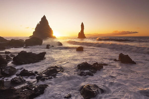 the stacks of Vik i Myrdal, seen from Reynisfjara beach, during a winter sunrise, southern Iceland
