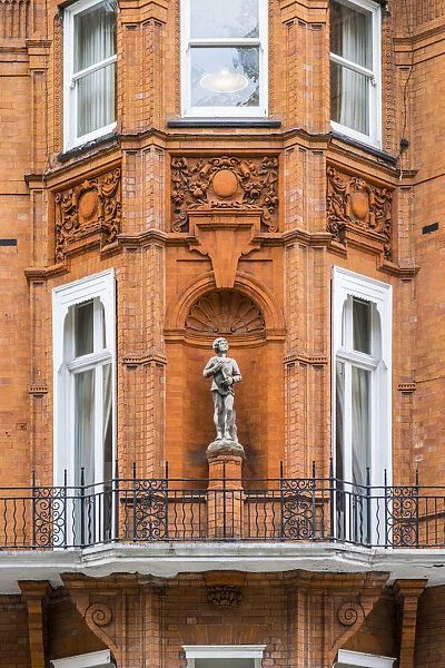 Statue on a brick terraced house, Kensington, London, England, UK