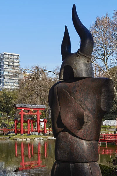 The statue of a Samurai in the foreground with the Buenos Aires Japanese Garden