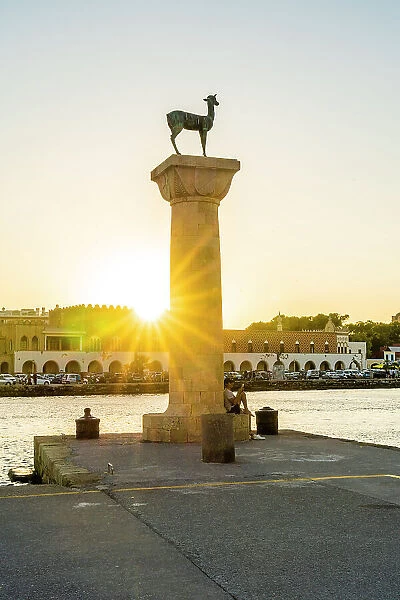 The statues of the Myth Colossus of Rhodes at sunset, Mandraki Marina and Port, Rhodes Town, Rhodes, Dodecanese Islands, Greece