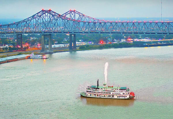 Steamboat paddles out of the Port of New Orleans on the Mississippi River. The Crescent City Connection Bridges, Louisiana, USA