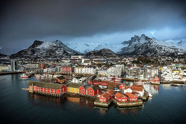Storm clouds in the foggy sky over the snowcapped mountains surrounding Svolvaer, aerial view, Lofoten Islands, Norway