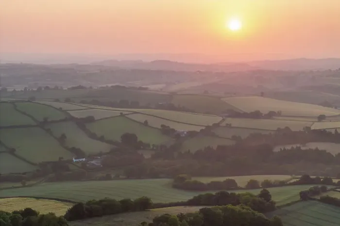 Framed Print : Summer sunrise over the rolling countryside of Dartmoor, Devon, England. Summer (June) 2023