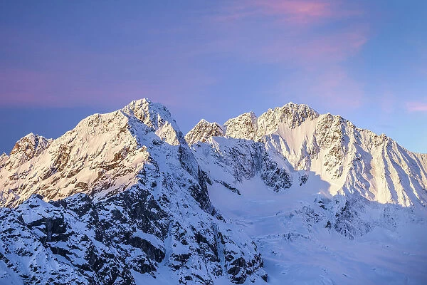The sun is rising on the north wall of the Disgrazia Mountain and on Ventina Peak