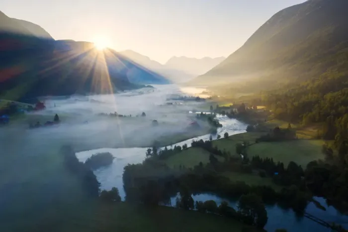 Framed Print : Sunburst during a foggy sunrise over Stryneelva river and fields, aerial view, Stryn