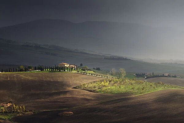 sunlight during a rain storm on a farmhouse Val d Orcia Tuscany, Italy