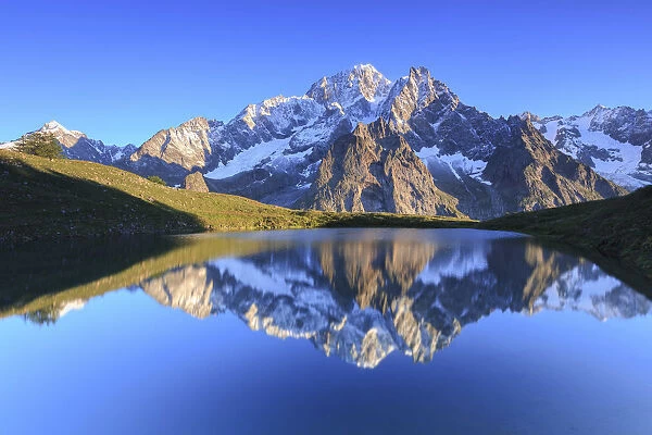 The sunlit Mont Blanc is reflected in Lac Checrouit. Checrouit Lake, Veny Valley