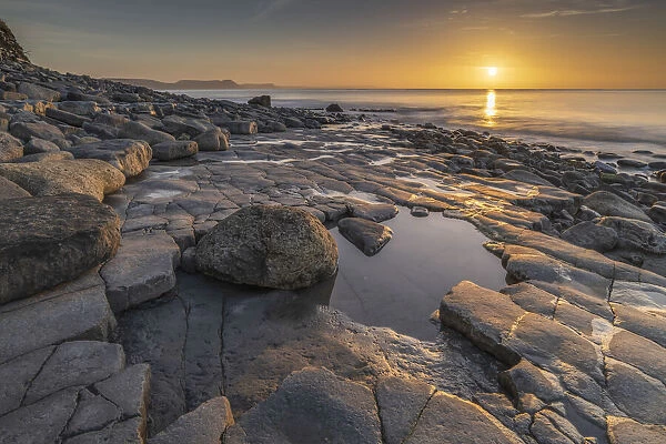 Sunrise over Lyme Bay from the Ammonite Pavement, Lyme Regis, Dorset, England. Winter (February) 2022