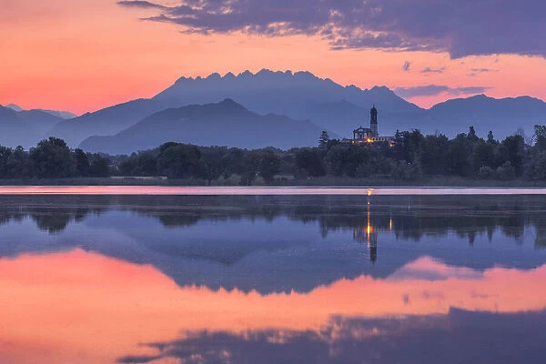 Sunrise on Resegone and Barro mount reflected on Pusiano lake, Garbagnate Rota church