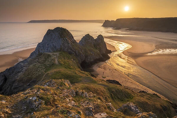 Sunset over Three Cliffs Bay on the spectacular Gower coastline, South Wales, UK. Spring (March) 2022