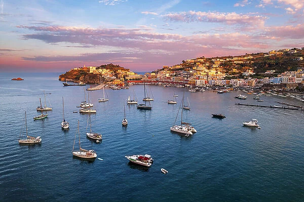 Sunset above the colorful fishing village of Ponza with boats anchored in the bay, aerial view, Ponza island, Pontine islands, Tyrrhenian Sea, Latina province, Latium, Italy