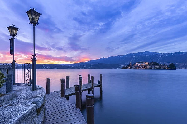 Sunset near a pier in front of San Giulio island and Lake Orta
