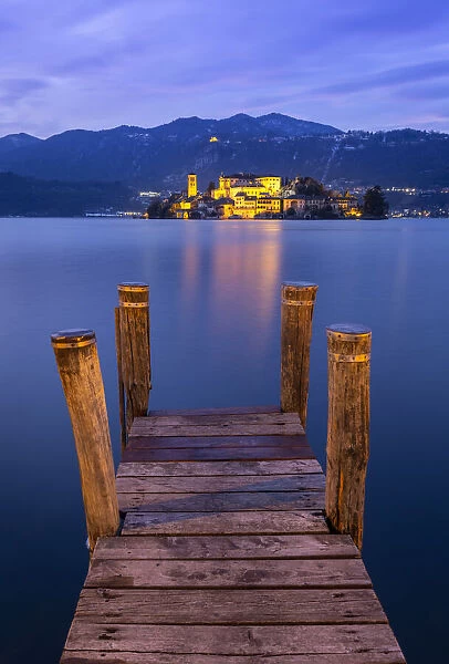 Sunset near a pier in front of San Giulio island and Lake Orta
