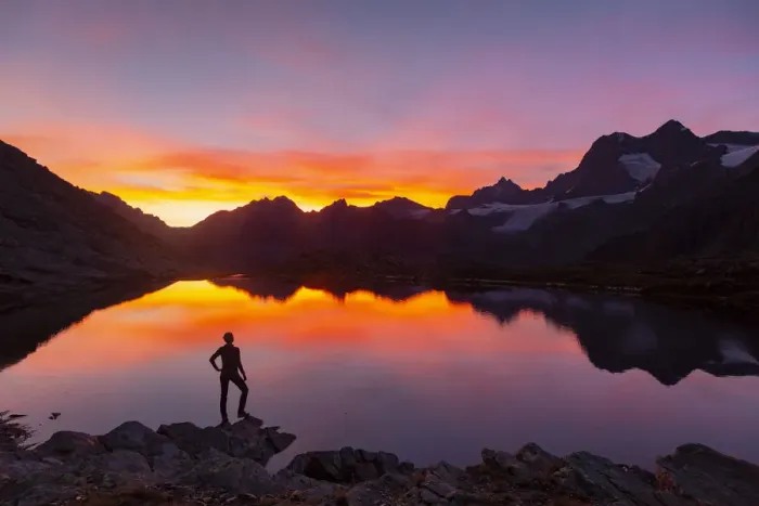 Framed Print : Sunsetscape of an hiker at Confinale pass lake during a summer sunset Framed Print : Sunsetscape of an hiker at Confinale pass lake during a summer sunset