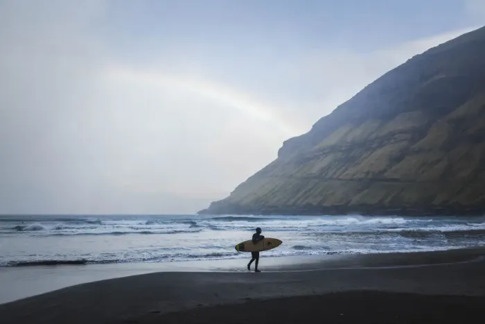 Framed Print : A surfer walking along the beach in Tjornuvik. Streymoy, Faroe Islands Framed Print : A surfer walking along the beach in Tjornuvik. Streymoy, Faroe Islands