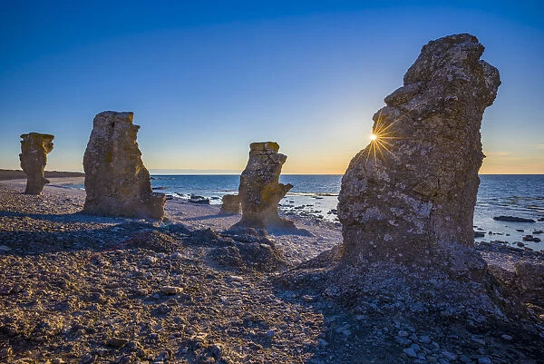 Sweden, Faro Island, Langhammars Area, Langhammar coastal limestone raukar rock, sunset