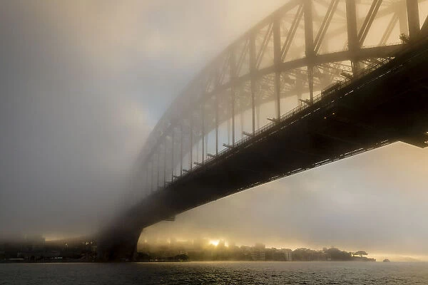 Sydney Harbour Bridge in fog at sunrise, Sydney, New South Wales, Australia