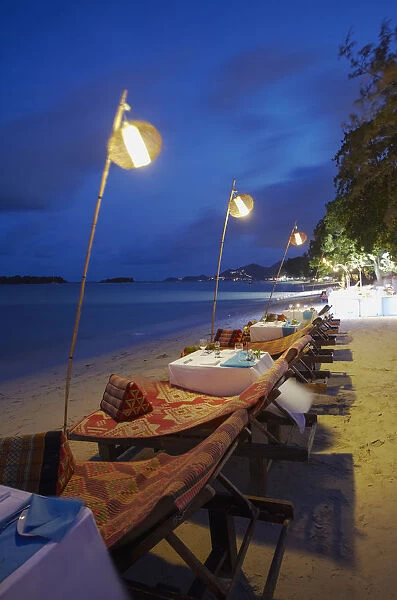 Tables set for dinner at Amari Palm Reef on Chaweng beach at dusk, Ko Samui, Thailand