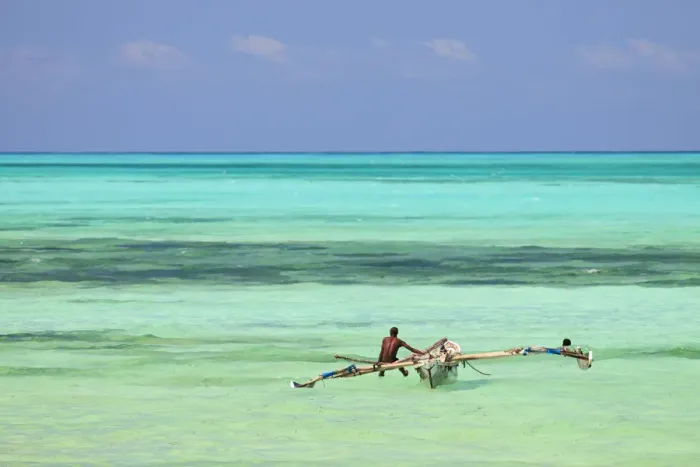 Framed Print : Tanzania, Zanzibar, Unguja, Jambiani. A man sits on his boat near the shore Framed Print : Tanzania, Zanzibar, Unguja, Jambiani. A man sits on his boat near the shore