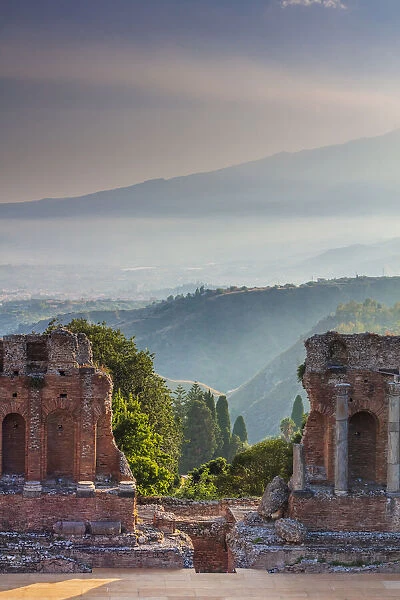 Taormina, Sicily. Sun setting on the greek theater with Etna volcano in the background