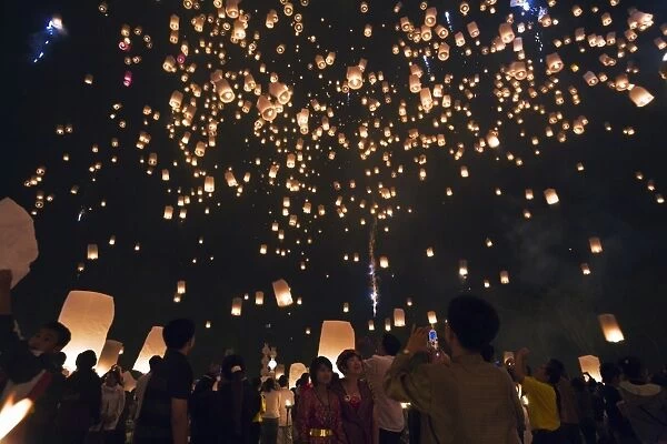 Thailand, Chiang Mai, San Sai. Revellers launch khom loi (sky lanterns) into the night sky during the Yi Peng festival. The ceremony is a Lanna (northern Thailand) tradition and coincides with Loy Krathong festivities. The khom loi are